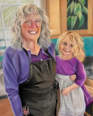 A woman and her young granddaughter, posing in flour covered aprons in the kitchen
