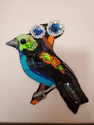 Neon green, blue, and orange paradise tanager rendered in embroidery and beads