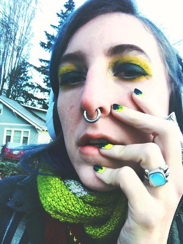 Matching eye and nail makeup, a toxic neon and teal green speckled with white