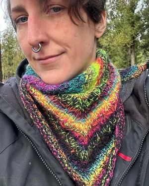 Stephanie wearing a black and white neon rainbow triangle scarf