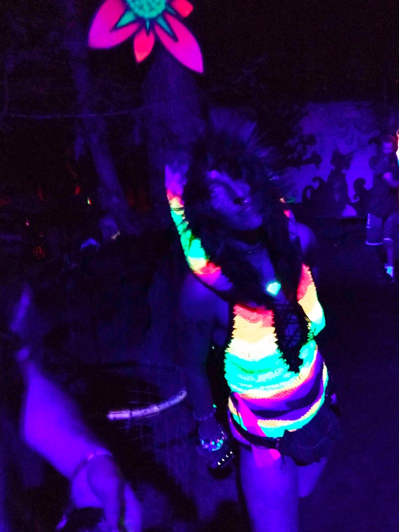 the rainbow onesie under UV light, glowing brightly against a dark purple background