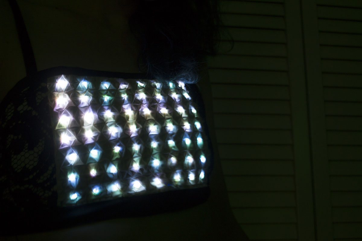 a matrix of blue green lights under textured fabric